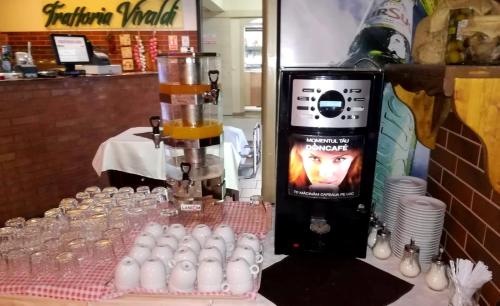 a table with a bunch of glasses and a blender at West Plaza Residence in Bucharest