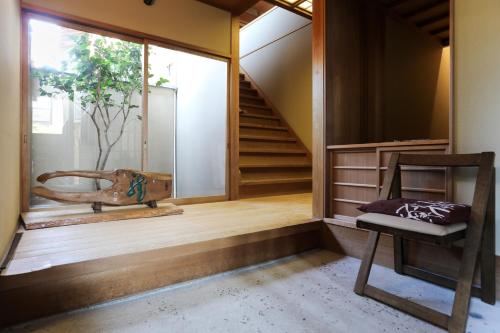 a room with a staircase and a chair and a window at Konuka Yakushi Temple House in Kyoto