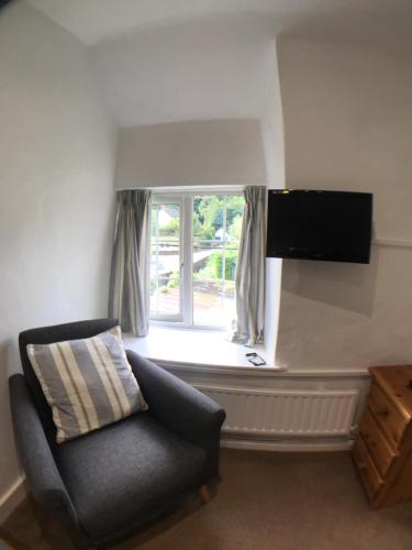 a living room with a chair and a window at The White Horse Inn in Washford