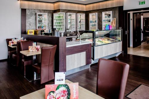 a restaurant with a counter and some tables and chairs at Hotel Bolte in Salzbergen