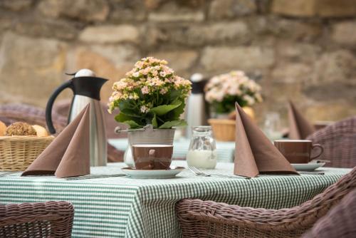 a table with a green table cloth with flowers and napkins at Hotel am Goethehaus in Weimar