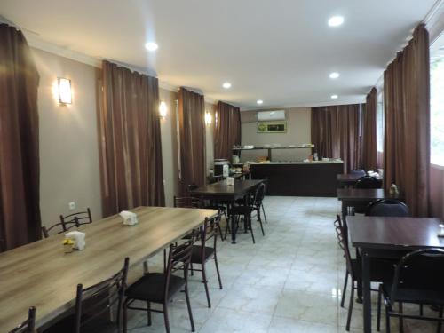 a dining room with tables and chairs and a counter at Alma-Ata Hotel in Borjomi