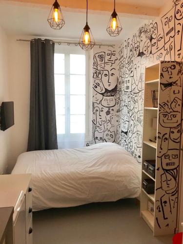 - une chambre avec un lit et un mur recouvert de graffitis dans l'établissement Maison Du Vieux Panier Vieux Port, à Marseille