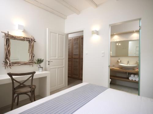 a bedroom with a bed and a bathroom with a sink at Villa Marandi Luxury Suites in Stelida