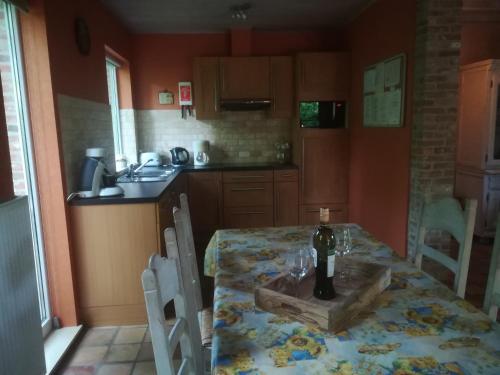 a kitchen with a table with a bottle of wine on it at Rainbow Lodge in Ursel