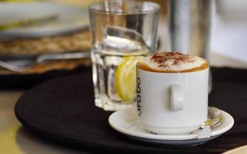 una taza de café sentada en una mesa con una bebida en Hotel Sa Tuna, en Begur