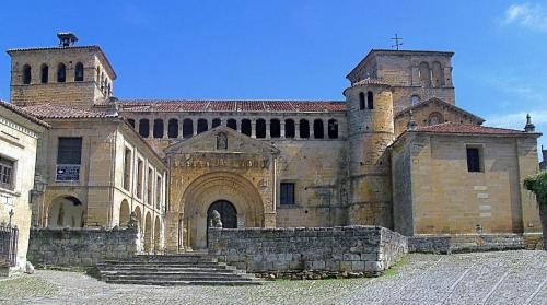 un grand bâtiment en briques avec une croix au-dessus dans l'établissement Posada Adela, à Santillana del Mar