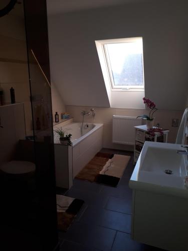 a bathroom with a tub and a sink and a window at Ferienhaus Wunderland in Kirchenbruch