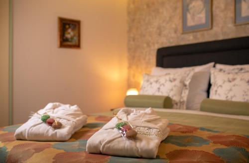 two pairs of slippers on a bed in a bedroom at Casa Boutique Hotel in Nahariyya