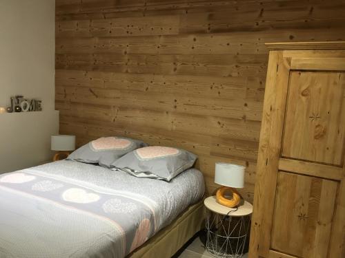 a bedroom with a bed with a wooden wall at chez karine et julie in La Rochette
