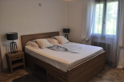 une chambre avec un lit avec des draps blancs et des fenêtres dans l'établissement Les Prairies de l'Encrême, à Céreste