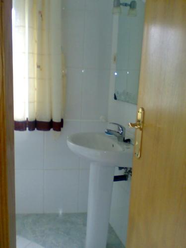 a white bathroom with a sink and a shower at Casa de la Abuela in Bubaces