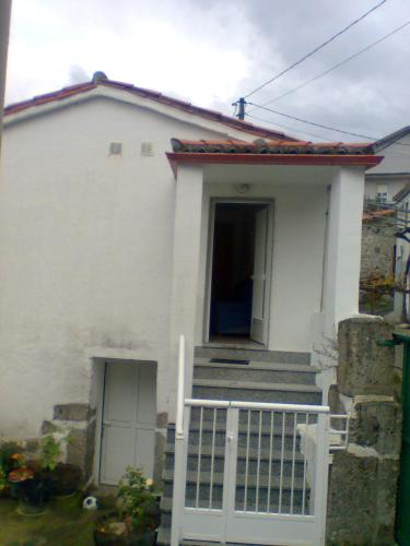 a white house with a white gate and stairs at Casa de la Abuela in Bubaces