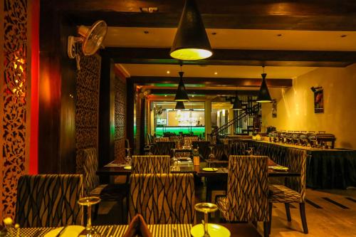 een restaurant met tafels en stoelen en een bar bij Oak Ray City Hotel in Kandy