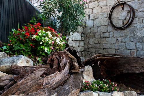 a wooden log with flowers in a garden at Villa Cindro House in Podstrana