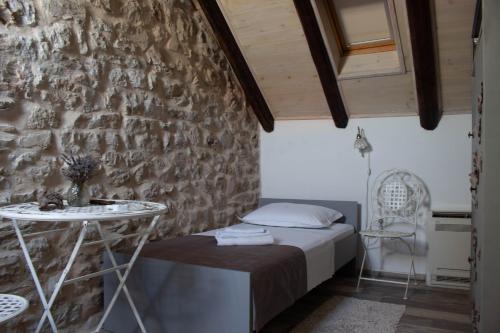 a bedroom with a bed and a stone wall at Villa Cindro House in Podstrana