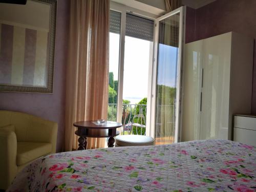 a bedroom with a bed and a window with a view at Hotel Mirabello in Sirmione