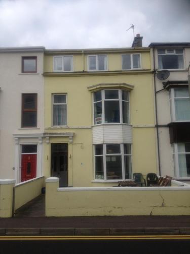 a yellow house with windows on a street at Causeway Coast Independent Hostel in Portstewart