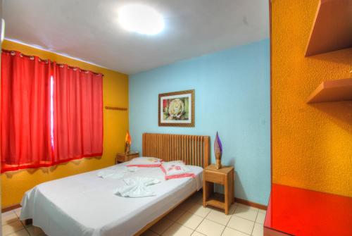 - une petite chambre avec un lit aux murs colorés dans l'établissement Flat Luxo Ponta Negra, à Natal