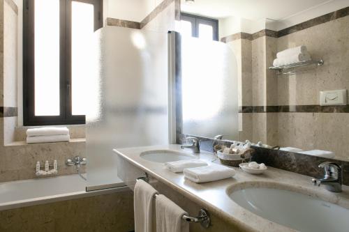 bagno con lavandino e specchio di Katane Palace Hotel a Catania