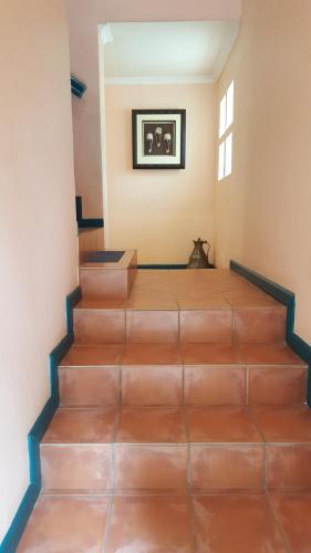 a staircase in a house with brown tile floors at Durbanville Place - 3 bedroom apartment in Durbanville
