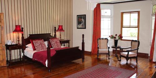 1 dormitorio con 1 cama, mesa y sillas en Kearsney Manor en Stanger