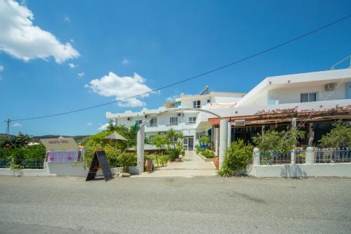 a large white building on the side of a street at Sea Harmony in Kalathos