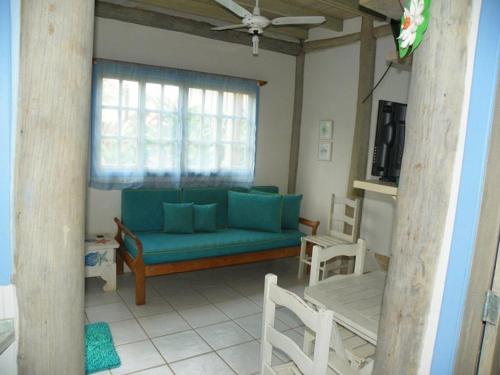 a living room with a blue couch and chairs at Chalés Musa de Maresias in Maresias