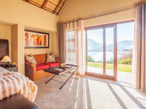 a living room with a couch and a large window at Kloofzicht Lodge & Spa in Muldersdrift