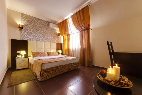 1 dormitorio con 1 cama y 1 mesa con velas en Villa Diego, en Rostov-on-Don