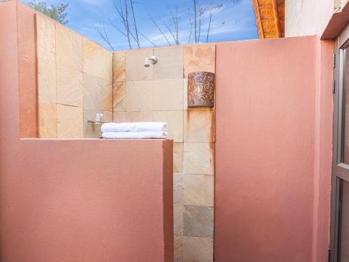 a bathroom with a shower with a towel on a wall at Kloofzicht Lodge & Spa in Muldersdrift