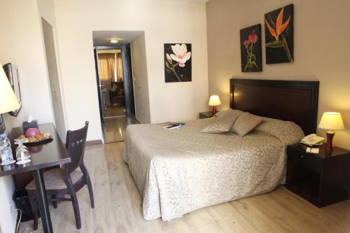 a bedroom with a bed and a desk with a phone at Mozart Hotel in Beirut