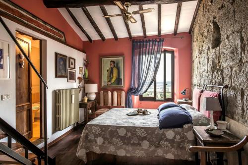 a bedroom with red walls and a bed with blue pillows at The Artists' Tower in San Gimignano