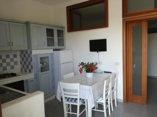 cocina con mesa con sillas y TV en Appartamenti La Chiandata, en Marina di Camerota