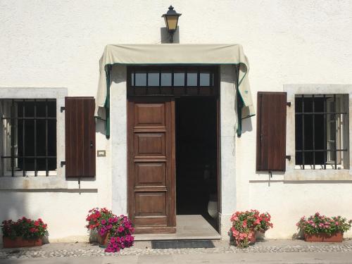una puerta a un edificio con dos ventanas y flores en Casa dell'emolo, en Clauzetto