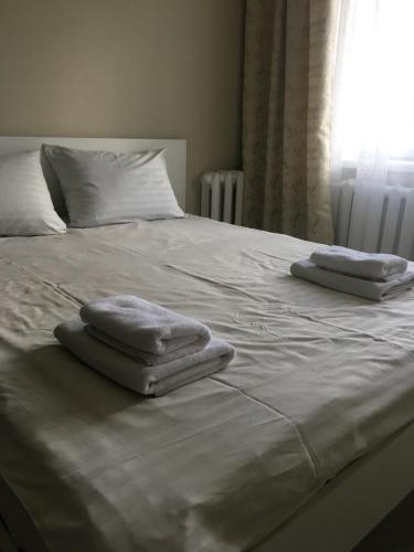 zwei Handtücher auf einem weißen Bett in der Unterkunft Апарт Рівне in Riwne