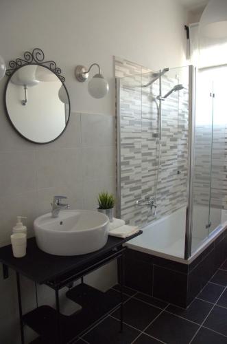 a bathroom with a sink and a tub and a mirror at Mandala Bed & Breakfast in Viterbo