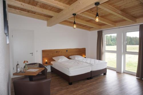 a bedroom with a bed and a table and a desk at Hotel Rappenhof in Breuna