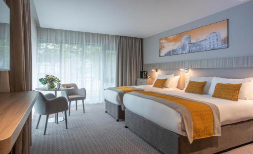 a hotel room with a large bed and a desk at Maldron Hotel Kevin Street, Dublin City in Dublin