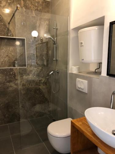 a bathroom with a shower and a toilet and a sink at Guest House Adriatica by Pinch in Pakoštane