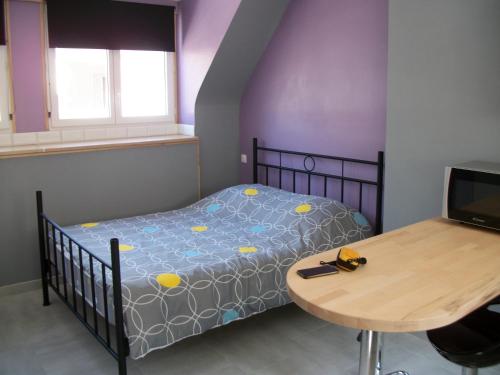 een slaapkamer met een bed en een houten tafel bij Les Mouettes 3 in Le Tréport