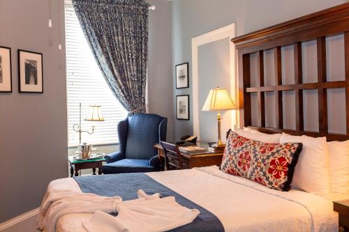 a hotel room with a bed and a chair at The Marshall House, Historic Inns of Savannah Collection in Savannah