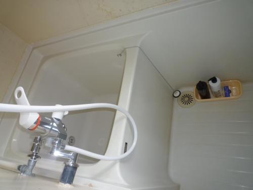 a bathroom sink with a faucet and a mirror at Futami Terrace B in Ise