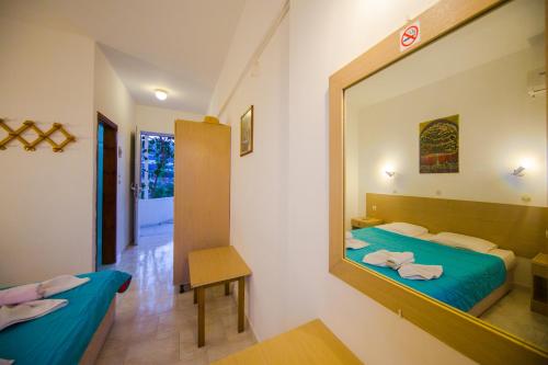a room with two beds and a mirror at Sea Harmony in Kalathos