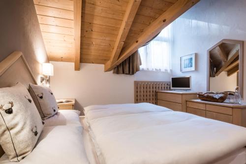 a bedroom with a bed and a desk with a computer at Ciasa Scjadu in San Cassiano