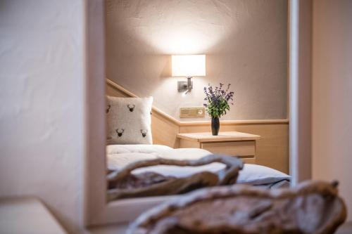 a reflection of a bedroom with a bed in a mirror at Ciasa Scjadu in San Cassiano