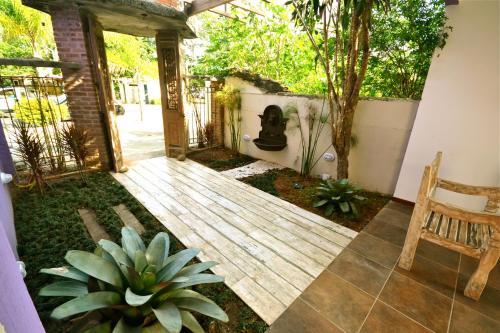 a garden with a wooden deck and a fireplace at Pousada do Centro in Búzios