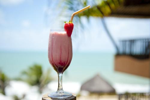 a red drink in a glass with a strawberry in it at Rifoles Praia Hotel e Resort in Natal