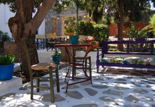 a patio with chairs and a table and a bench at Lato hotel in Agios Nikolaos