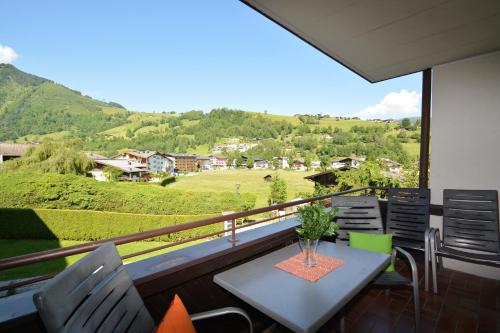a balcony with a table and chairs and a view at Appartements Domizil in Kaprun
